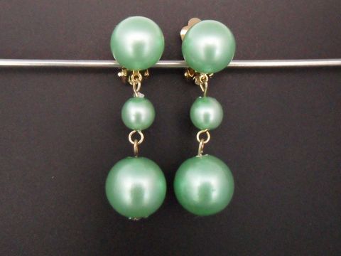 71881-0 Ohrclip in zeitlosem Design mit türkisfarbenen Kunstharzperlen und goldfarbenen Elementen, hergestellt von Juwelier Harnisch. Ideal für elegante Anlässe.