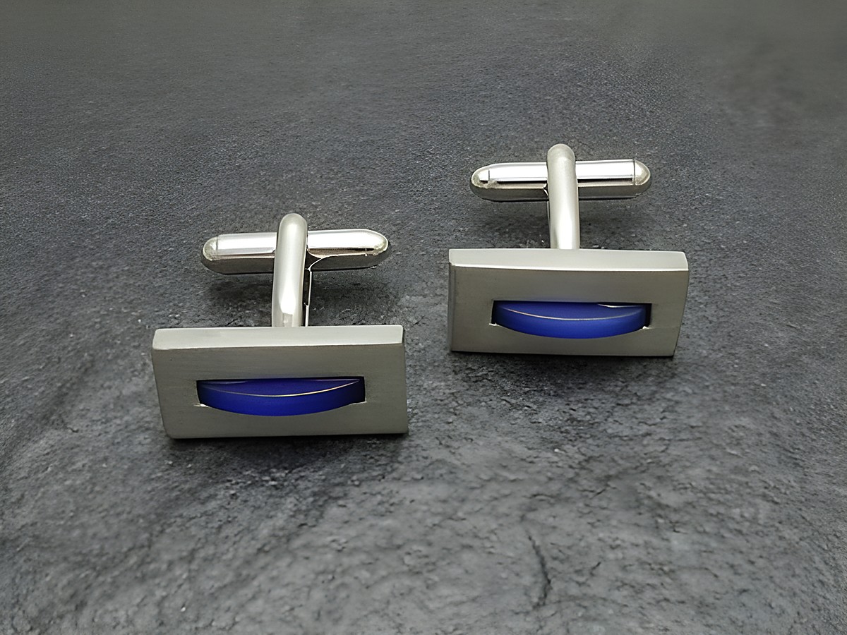 Manschettenknöpfe in silberfarben mit blauer Einlage, hergestellt von Juwelier Harnisch, elegantes Design für das perfekte Outfit.