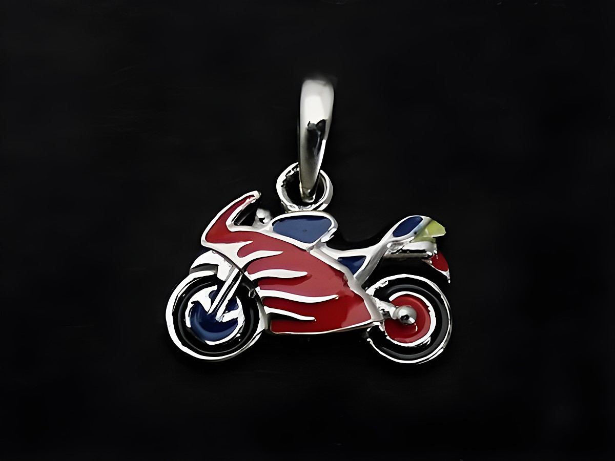 Silber Anhänger in Form eines sportlichen Motorrads mit roter, blauer und schwarzer Lackierung, geeignet für Kinder, Hersteller: Juwelier Harnisch.