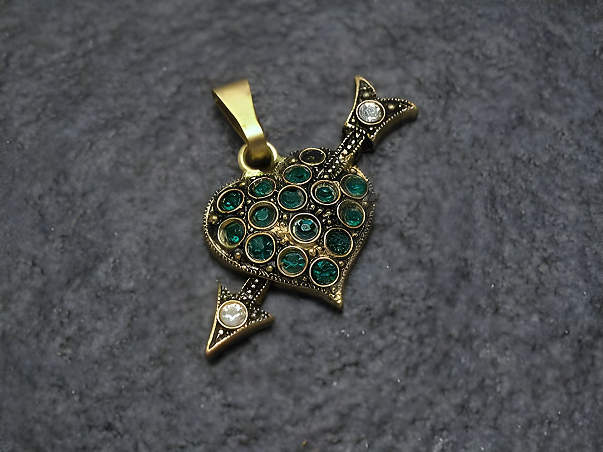 Grüner Strass Anhänger im Sexy City Look in Herzform mit Pfeilen, gefertigt von Juwelier Harnisch. Funktionsreicher und eleganter Schmuck, ideal für modische Akzente.