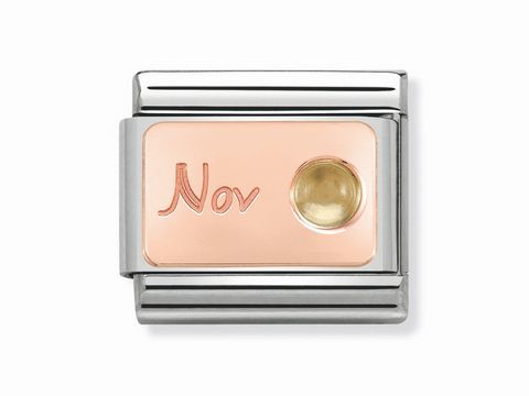 Monatsstein Rosé von Nomination, Classic 430508 11, für November, zeigt die Gravur "Nov" und einen runden goldenen Stein auf einem roséfarbenen Hintergrund.