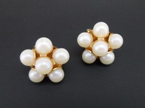 Ohrclip in weiß blumigem Design mit goldfarbener Fassung und synthetischen Zuchtperlen, hergestellt von Juwelier Harnisch. Ideal für elegante Anlässe.