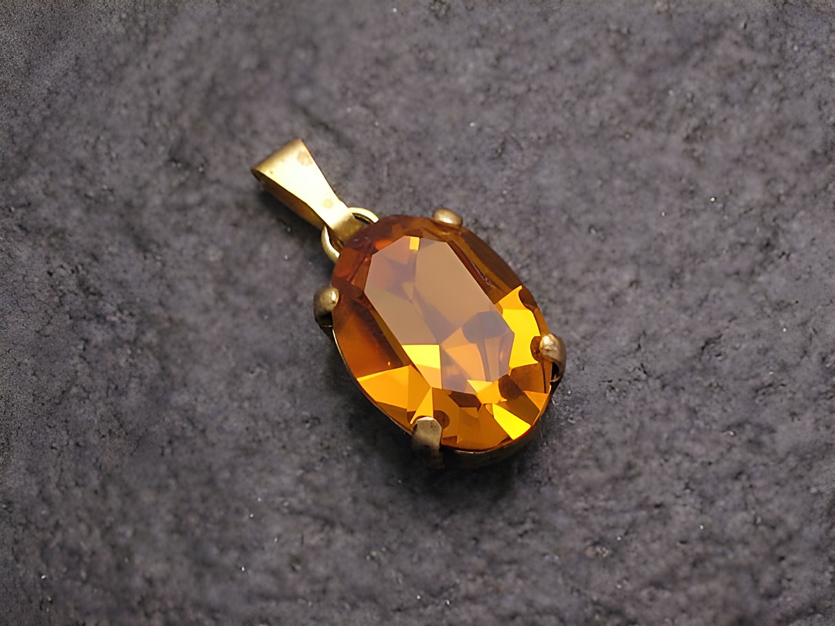 Gelber Strass Anhänger in ovaler Form mit goldfarbener Fassung, ideal für einen sexy City Look, hergestellt von Juwelier Harnisch, perfekt als Schmuckstück für verschiedene Anlässe.