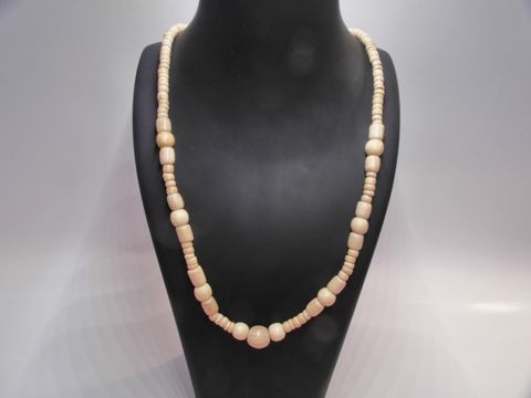 Holzkette Multiform in naturbraun mit einem Durchmesser von 29 mm und einer Länge von 60 cm, hergestellt von Juwelier Harnisch, präsentiert sich elegant auf einem schwarzen Präsentationsständer.