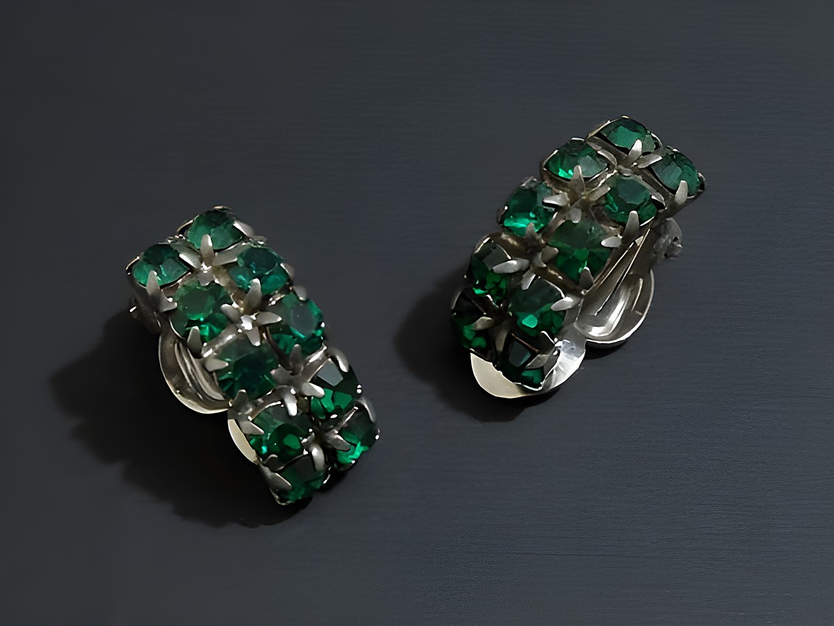 Strass Ohrclips in galantem Design mit smaragdgrünen Steinen und silberfarbener Fassung, hergestellt von Juwelier Harnisch, ideal für elegante Anlässe.