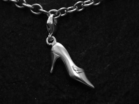 Charm Schuh aus Sterling Silber in Form eines Pumps, gefertigt von Juwelier Harnisch, mit praktischen Karabiner zur Befestigung, auf schwarzem Hintergrund abgebildet.