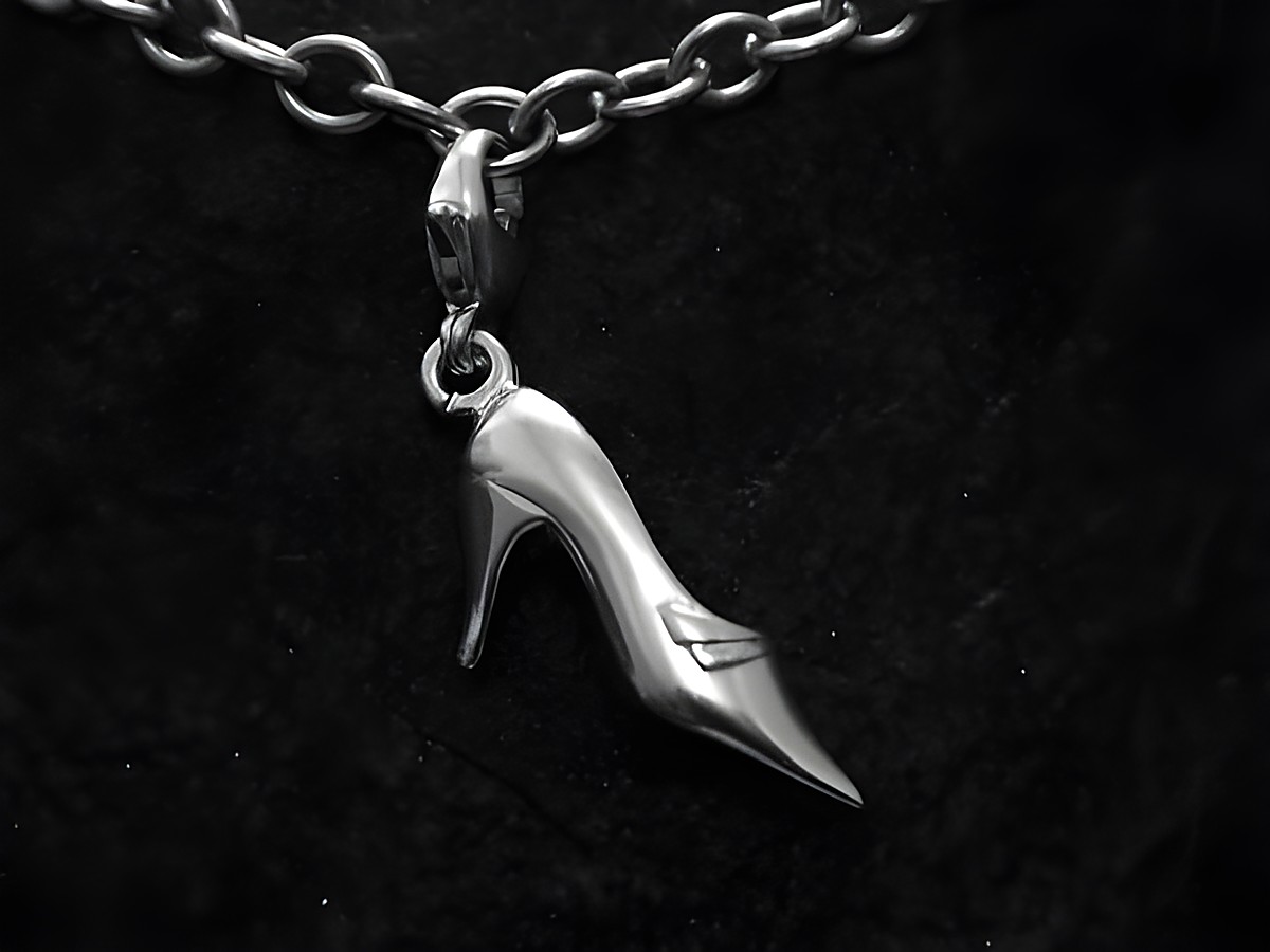 Charm Schuh aus Sterling Silber in Form eines Pumps, gefertigt von Juwelier Harnisch, mit praktischen Karabiner zur Befestigung, auf schwarzem Hintergrund abgebildet.