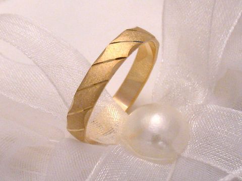 Trauring Ehering SANFT in Gold 585, Größe 54/17,2, Hersteller Juwelier Harnisch, zeigt eine elegante, matte Oberfläche mit dezentem Muster, auf einem weichen Tuch und einer Perle drapiert.
