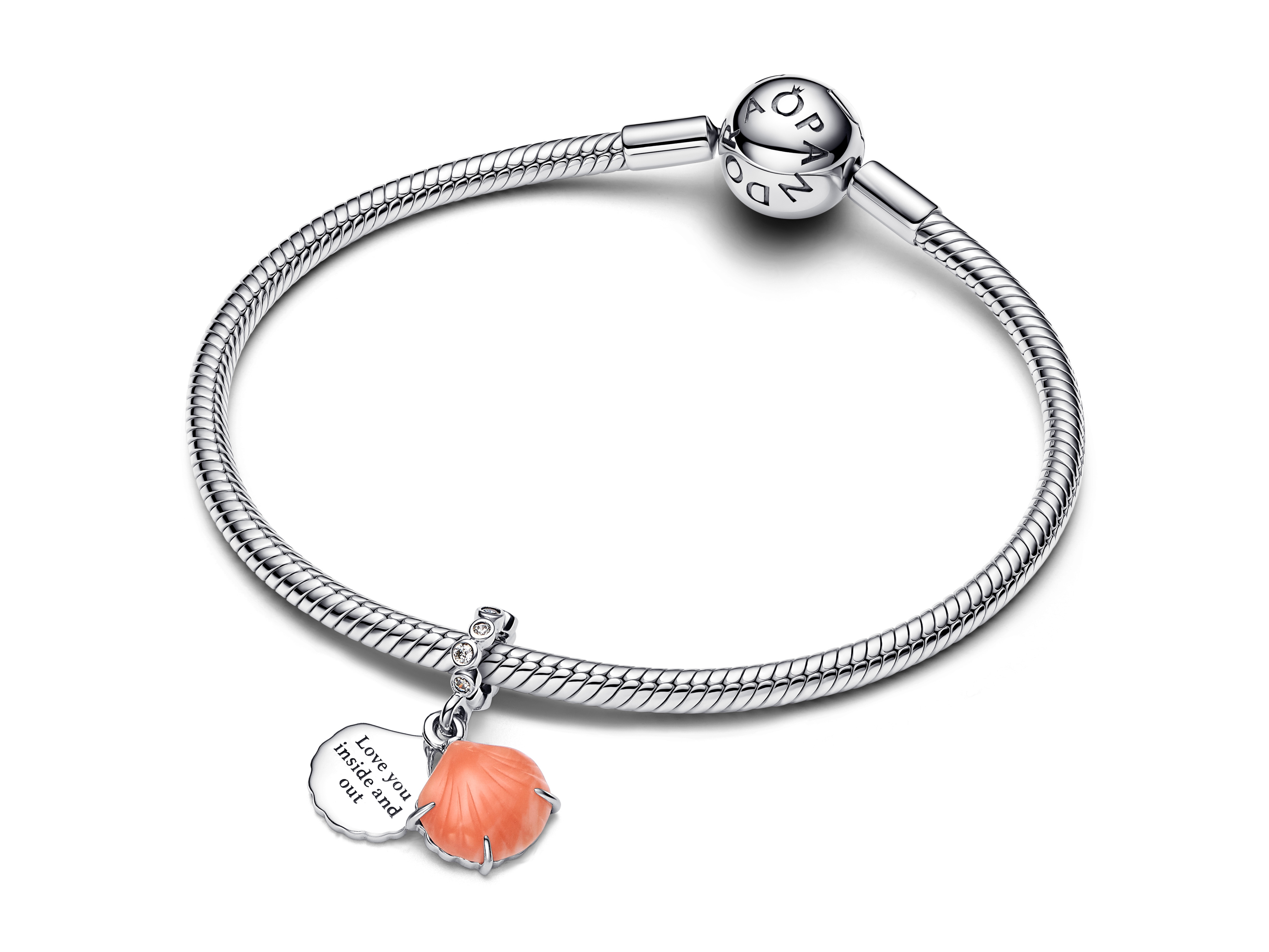 Korallenfarbener Muschel-Double-Dangle-Charm aus Sterling Silber von Pandora, präsentiert an einem filigranen Armband, mit einer gravierten Platte und glitzernden Elementen.