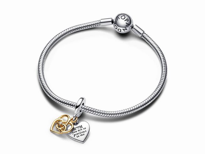 Doppelter Charm-Anhänger von Pandora aus Silber und Vergoldung mit lab-grown Diamant, an einem eleganten Armband befestigt, mit Herzmotiven und einer liebevollen Gravur für Mama.
