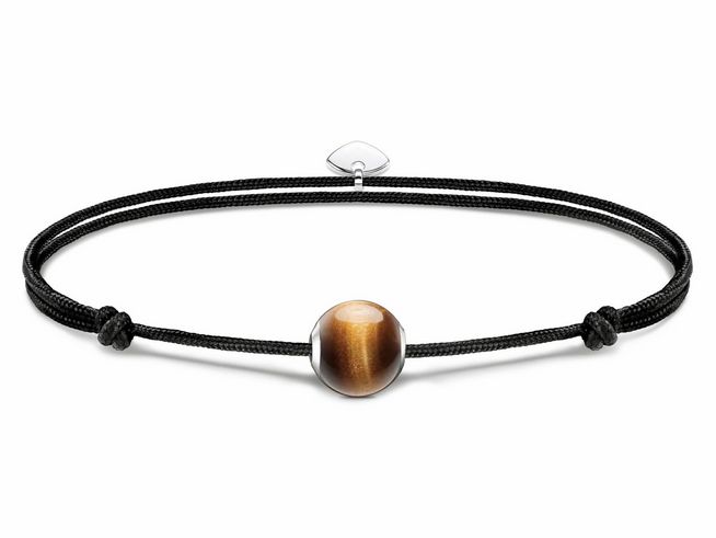 Das Armband aus schwarzem Textil hat einen zentralen Karma Bead aus Tigerauge in Braun und silberne Details, passend für Handgelenke bis 22 cm.