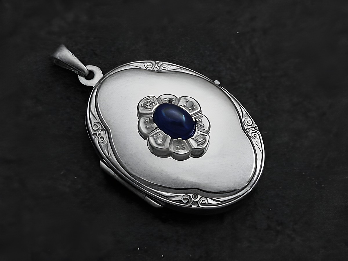 Saphir Medaillon Cabochon in rhodiniertem Sterling Silber von Juwelier Harnisch, mit ovaler Form und floralen Details, zentrales blauer Stein umgeben von kleinen Zirkonia.