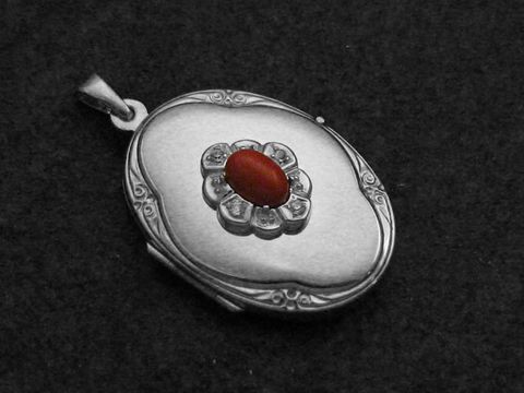 Medaillon aus Sterling Silber mit einem rot-braunen Jaspis Cabochon, umgeben von Zirkonia, hergestellt von Juwelier Harnisch. Elegantes Design mit floralen Motiven.
