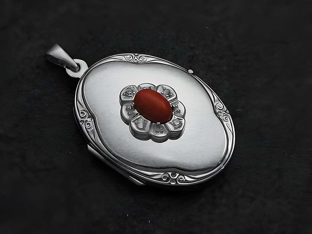 Medaillon aus Sterling Silber mit einem rot-braunen Jaspis Cabochon, umgeben von Zirkonia, hergestellt von Juwelier Harnisch. Elegantes Design mit floralen Motiven.