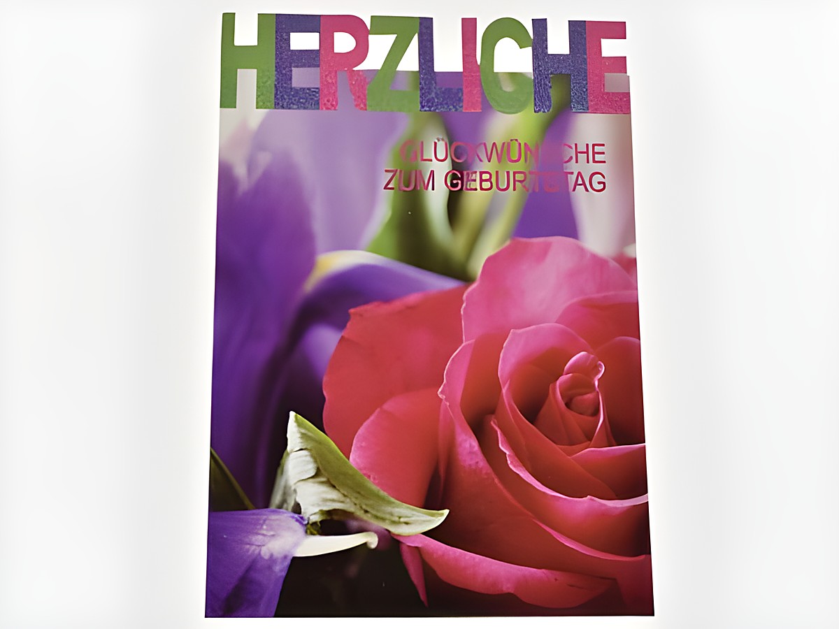 Eine Geburtstagskarte mit bunten Buchstaben, die "Herzliche Glückwünsche zum Geburtstag" sagen, und einer Rosenabbildung in verschiedenen Farben, hergestellt von Juwelier Harnisch.