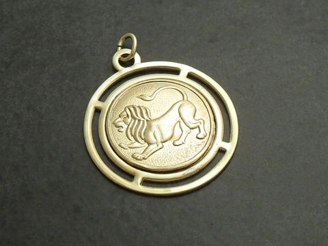 Goldfarbene, runde 3D-Platte mit dem Sternzeichen Löwe, Hersteller Juwelier Harnisch, zeigt einen stilisierten Löwen in erhobener Haltung auf einer schlichten Platte.