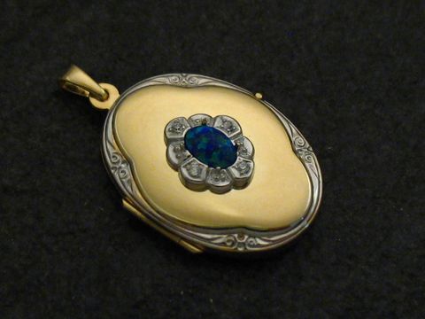 Ein bicolor Medaillon aus Gold 585 mit einem blauen Opal Cabochon in blühender Form, umgeben von kleinen glänzenden Elementen, hergestellt von Juwelier Harnisch.