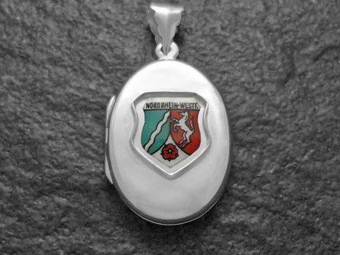 Silbernes Medaillon mit dem Wappen von Nordrhein-Westfalen, das ein rot-grünes Design mit Löwen und Wellen zeigt, hergestellt von Juwelier Harnisch.