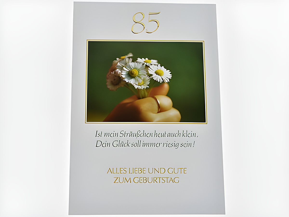 Geburtstagskarte mit der Zahl 85, dekoriert mit einem kleinen Blumenstrauß aus Gänseblümchen, begleitet von der Aufschrift "Alles Liebe und Gute zum Geburtstag" und einem herzlichen Spruch.
