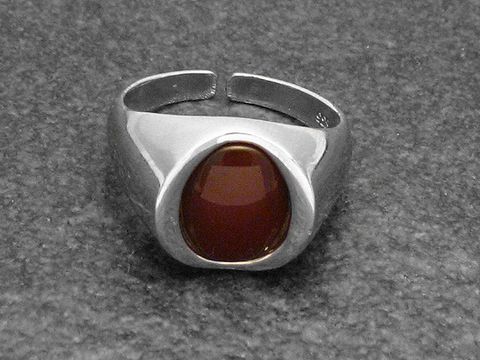 Silberring aus rhodiniertem Material mit einem ovale Karneolstein in der Mitte, modern und verstellbar, elegant und ansprechend, Hersteller Juwelier Harnisch.