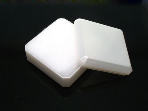 Hellbeige Geschenkschachtel für Schmuck mit einem Innenpolster aus weichem Material, die oben offen ist und auf einem schwarzen Untergrund liegt, Maße 4 cm, Hersteller Juwelier Harnisch.