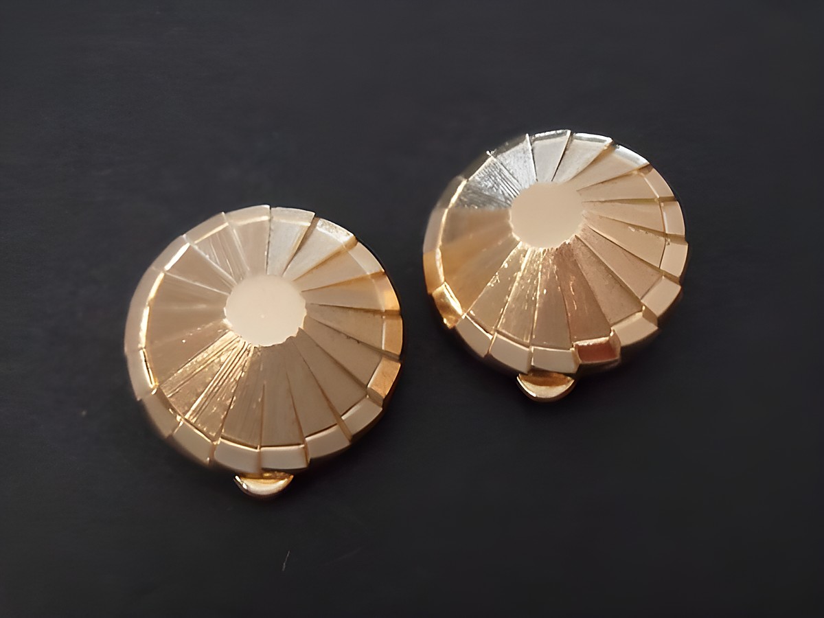 Zwei goldfarbene Ohrclips mit echter Goldauflage, Hersteller Juwelier Harnisch, zeitloses Design mit strahlenförmigen Mustern, Durchmesser von 19 mm, klassische und elegante Schmuckstücke.
