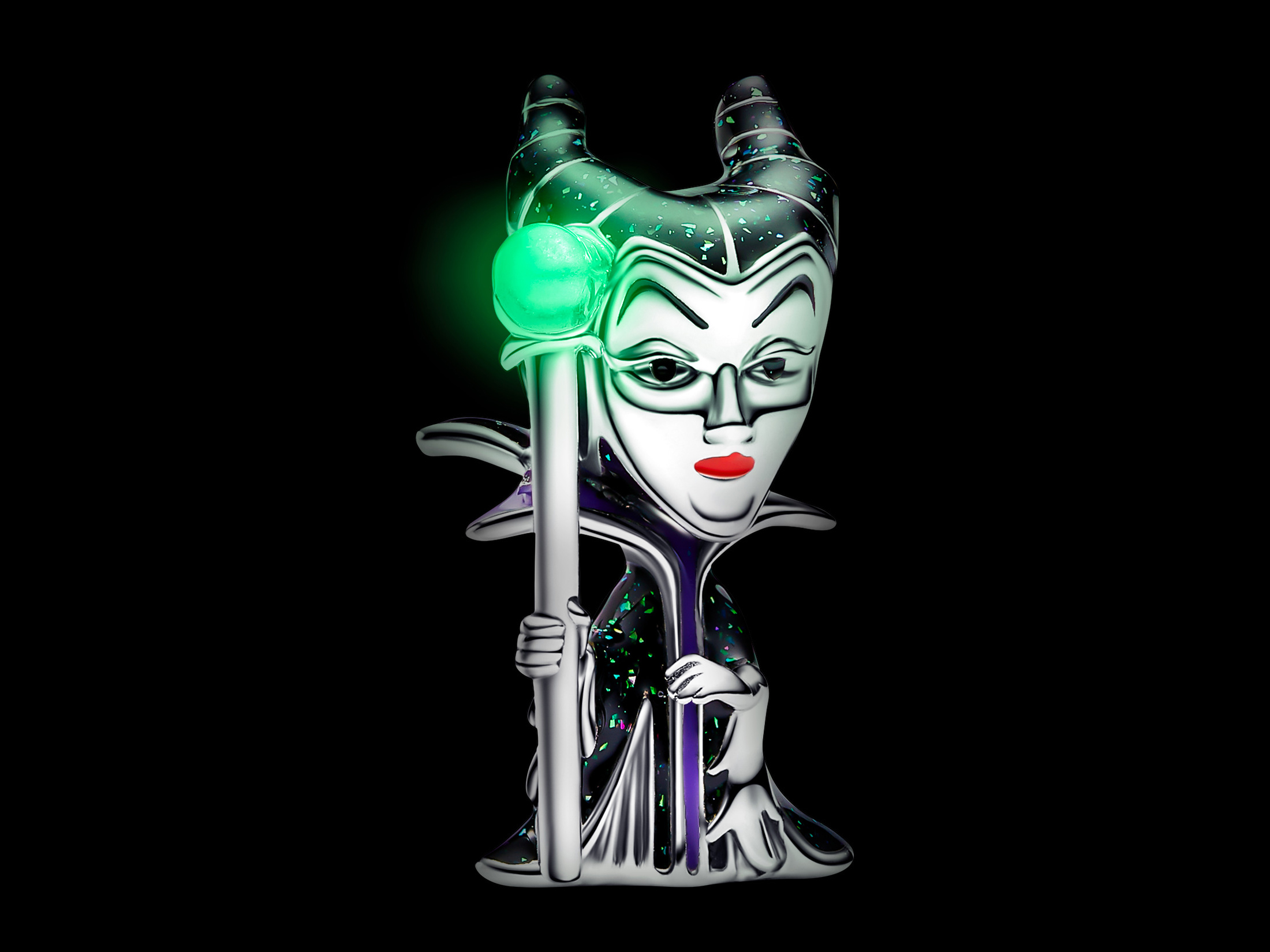 Der Anhänger zeigt die Disney-Schurkin Maleficent in silberner Ausführung mit detailreicher Bemalung, leuchtend in der Dunkelheit durch einen grünen Zauberstab.