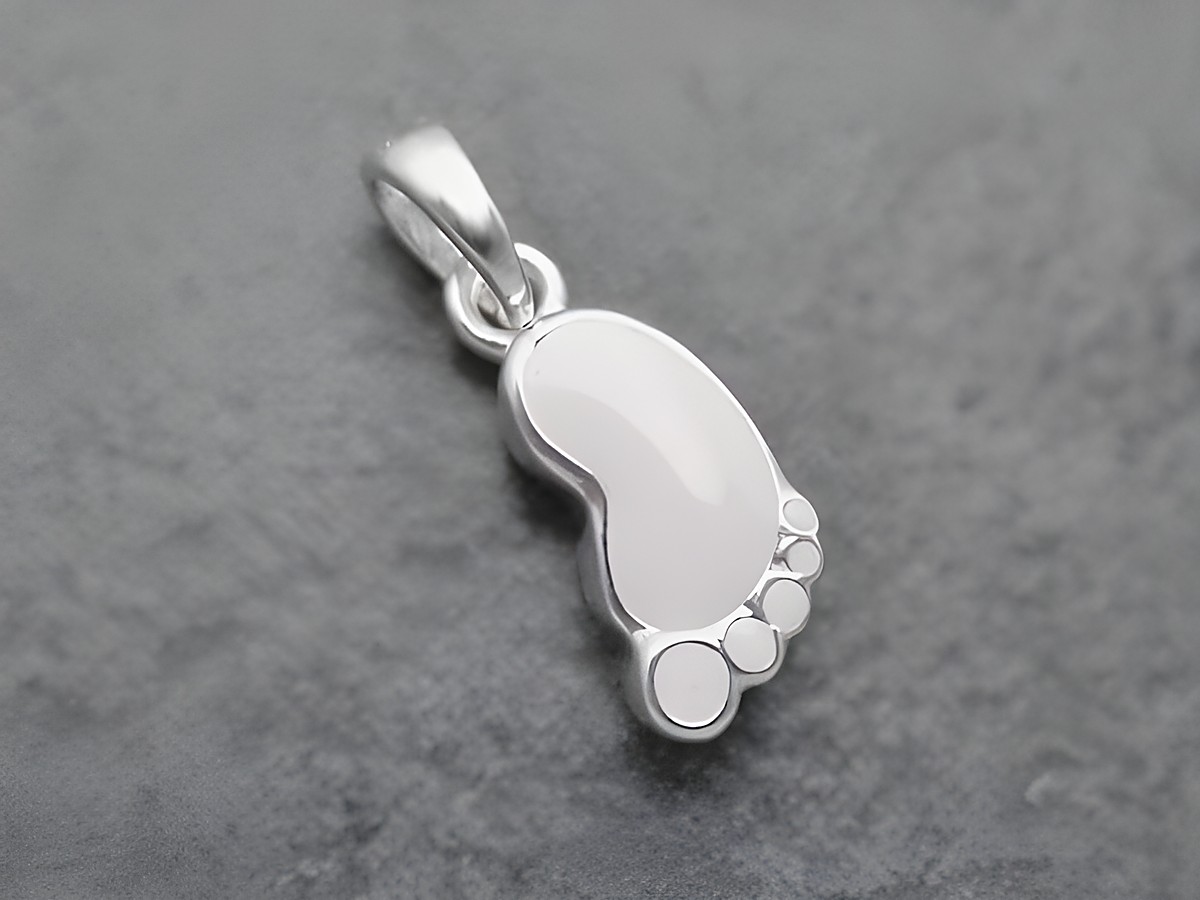Anhänger in Form eines Babyfußabdrucks aus sterling Silber, weiß lackiert und niedlich, ideal als Schmuckstück für Kinder, Hersteller Juwelier Harnisch.