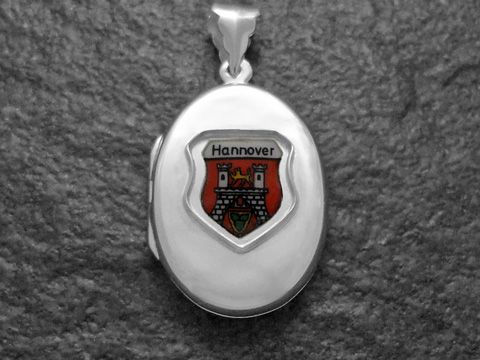 Silbernes Medaillon mit dem Stadtwappen von Hannover, angezeigt durch ein farbiges Emblem, elegant gestaltet, hergestellt von Juwelier Harnisch in Niedersachsen.
