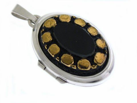 Medaillon mit Cabochon in schwarzer Farbe, umgeben von goldenen Details, gefertigt aus Sterling Silber, Hersteller Juwelier Harnisch. Elegant und stilvoll.