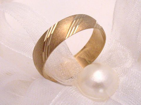 Trauring Ehering PRETTY in Gold 333 Gr. 54/17,2 von Juwelier Harnisch, elegant mit dekorativer Oberflächenstruktur, liegt auf weißem Organza und einer Perle.