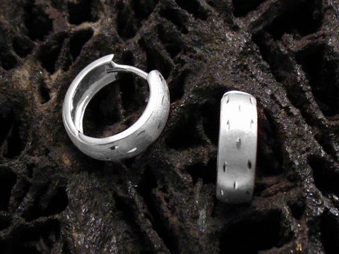 Elegante Creolen aus 925 Sterling Silber für Kinder, hergestellt von Juwelier Harnisch, auf einem dunklen, strukturierten Hintergrund abgebildet.