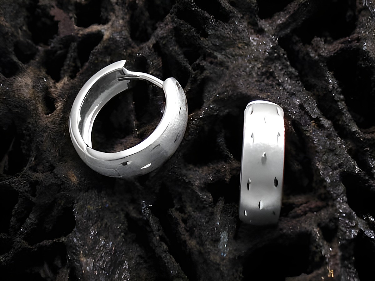 Elegante Creolen aus 925 Sterling Silber für Kinder, hergestellt von Juwelier Harnisch, auf einem dunklen, strukturierten Hintergrund abgebildet.