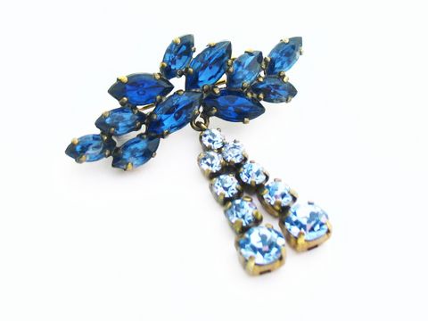 Blaue Strass Brosche im sexy City Look von Juwelier Harnisch, verziert mit tiefblauen und hellblauen Steinen, ideal als auffälliges Accessoire für verschiedene Outfits.