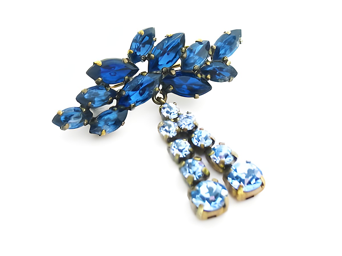 Blaue Strass Brosche im sexy City Look von Juwelier Harnisch, verziert mit tiefblauen und hellblauen Steinen, ideal als auffälliges Accessoire für verschiedene Outfits.