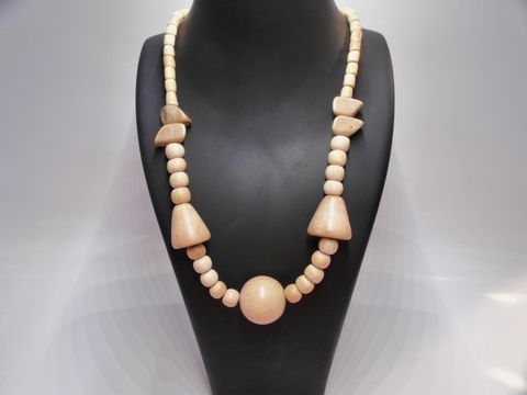 Holzkette Multiform 25 mm naturbraun 60 cm Holz Schmuck von Juwelier Harnisch, präsentiert auf einem schwarzen Schmuckständer, mit verschiedenen Holzelementen in unterschiedlichen Formen.