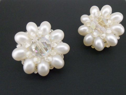 Ohrclip in weiß blumigem Design mit goldfarbenen Akzenten und synthetischen Zuchtperlen, hergestellt von Juwelier Harnisch, elegantes Schmuckstück für besondere Anlässe.