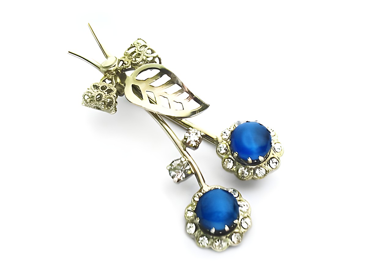 Brosche in Form einer Blume in blau und weiß mit Strasssteinen, Hersteller Juwelier Harnisch, elegante und funkelnde Dekoration für einen besonderen Anlass.