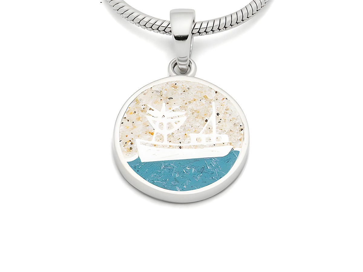 DUR Anhänger Kutter aus Sterling Silber mit runder Form, zeigt ein stilisiertes Schiff in Weiß auf blauem Hintergrund und sandiger Textur, ideal als maritimes Schmuckstück.
