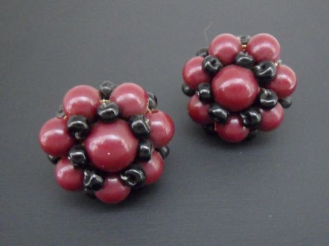 Dunkelrote und schwarze, blumig gestaltete Ohrclips mit goldfarbenen Elementen und synthetischen Zuchtperlen, Hersteller Juwelier Harnisch, elegant und auffällig.