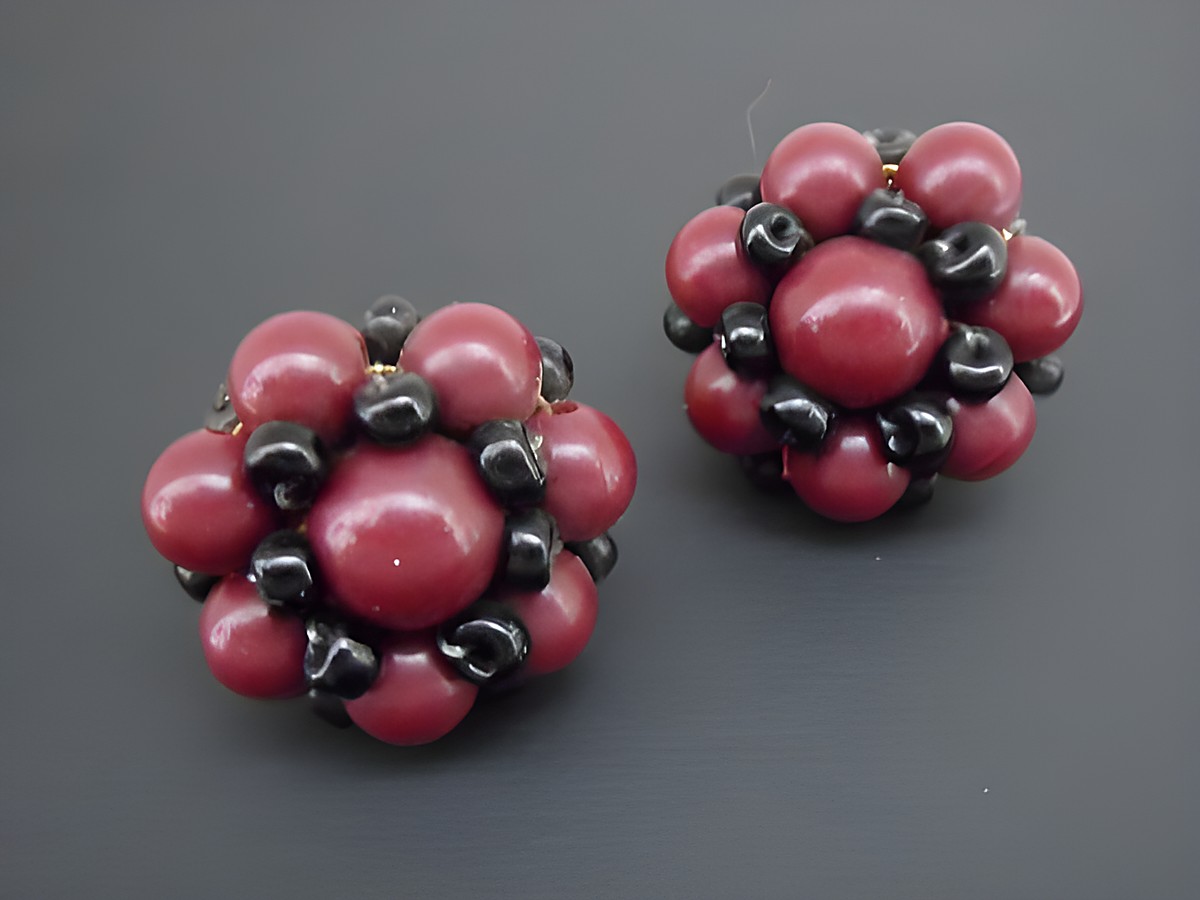 Dunkelrote und schwarze, blumig gestaltete Ohrclips mit goldfarbenen Elementen und synthetischen Zuchtperlen, Hersteller Juwelier Harnisch, elegant und auffällig.