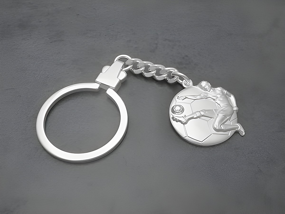 Schlüsselanhänger Fußball aus echtem Silber, gefertigt von Juwelier Harnisch, zeigt einen spielenden Fußballer auf einem Fußball, ideale Geschenkidee für Fußballfans.