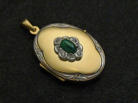 Medaillon aus Gold 333 bicolor mit einem Malachit grün Cabochon, umgeben von silberfarbenen Details, hergestellt von Juwelier Harnisch. Ein elegantes Schmuckstück.