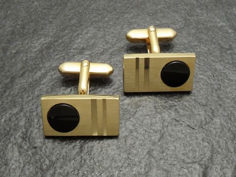 20056-0 Manschettenknöpfe vergoldet im Onyx-Look von Juwelier Harnisch, goldfarben mit einem eleganten, rechteckigen Design und schwarzem Onyx-Einsatz. Ideal für formelle Anlässe.