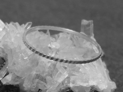Ein filigraner silberner Ring mit rhodiniertem Finish, 1 mm breit, Größe 50 / 15,8 mm, liegt auf glitzerndem Kristall. Hersteller ist Juwelier Harnisch, bis Größe 50 / 15,9 erhältlich.