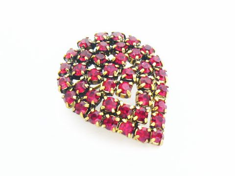 Rote Strass Brosche im sexy City Look in Blattform, hergestellt von Juwelier Harnisch, besticht durch funkelnde rote Strasssteine auf goldenem Untergrund.