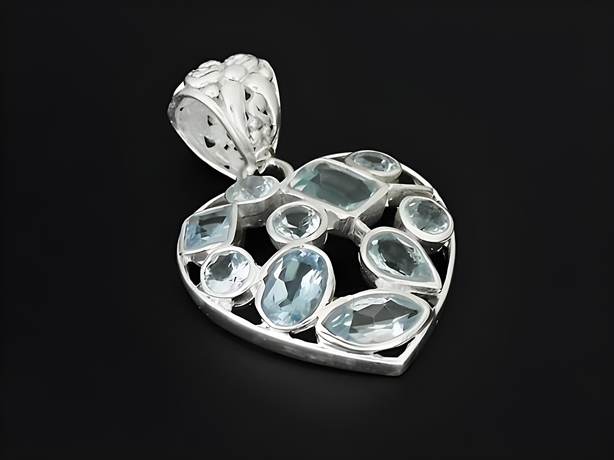 Silber Anhänger in Herzform mit facettiertem Topas, romantisch gestaltet, hergestellt von Juwelier Harnisch, verziert mit weiteren Steinen für besondere Akzente.