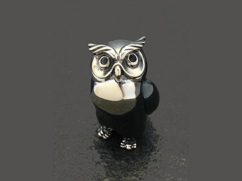 Eine stehende Eule aus Silber, gefertigt von Juwelier Harnisch, 28 mm hoch. Die Figur ist plastisch gestaltet und zeigt detaillierte Augen sowie eine elegante Form.