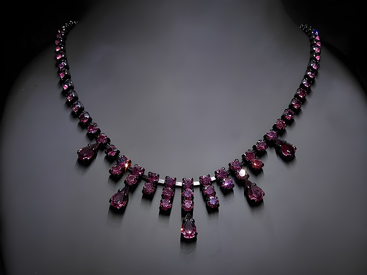 Strasskette in glanzvollem Lila, aus Strassschmuck gefertigt, mit einer Länge von 44,5-47,5 cm, Hersteller: Juwelier Harnisch, Fassung schwarz.