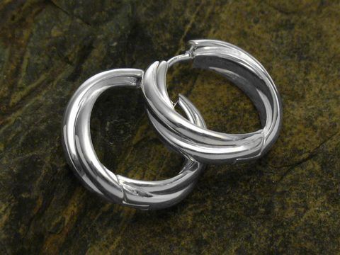 Verschlungene moderne Creolen aus 925 Sterling Silber von Juwelier Harnisch, Durchmesser bis 25 mm, glänzendes Finish auf natürlichem Untergrund.